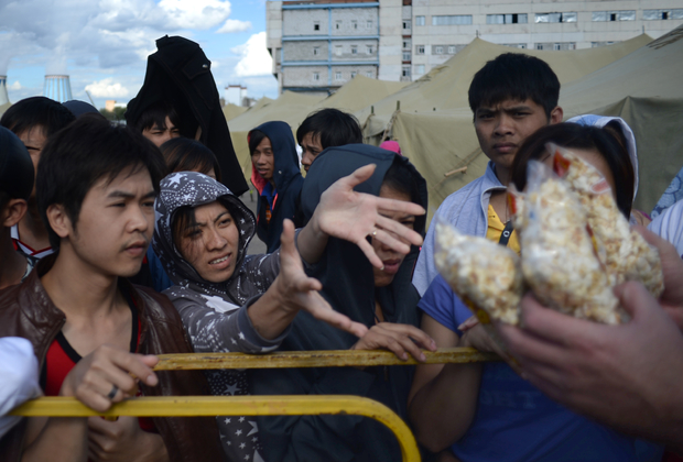 Мигранты в палаточном лагере в Гольяново принимают гуманитарную помощь